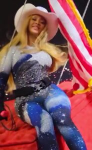 Beyoncé in a cowboy hat and sparkly bodysuit on a flying car during a concert.
