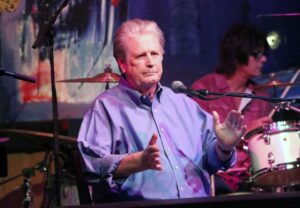 Brian Wilson speaking at a microphone.