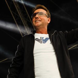 Man wearing sunglasses and a black zip-up jacket.
