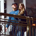 Dakota Johnson and Chris Martin on a balcony.