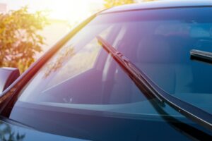 Woman in car explaining how hot weather cracked her windshield.