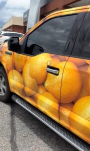 Ford F-150 truck with an orange wrap.
