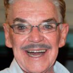 Headshot of a smiling man wearing glasses.