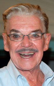 Headshot of a smiling man wearing glasses.