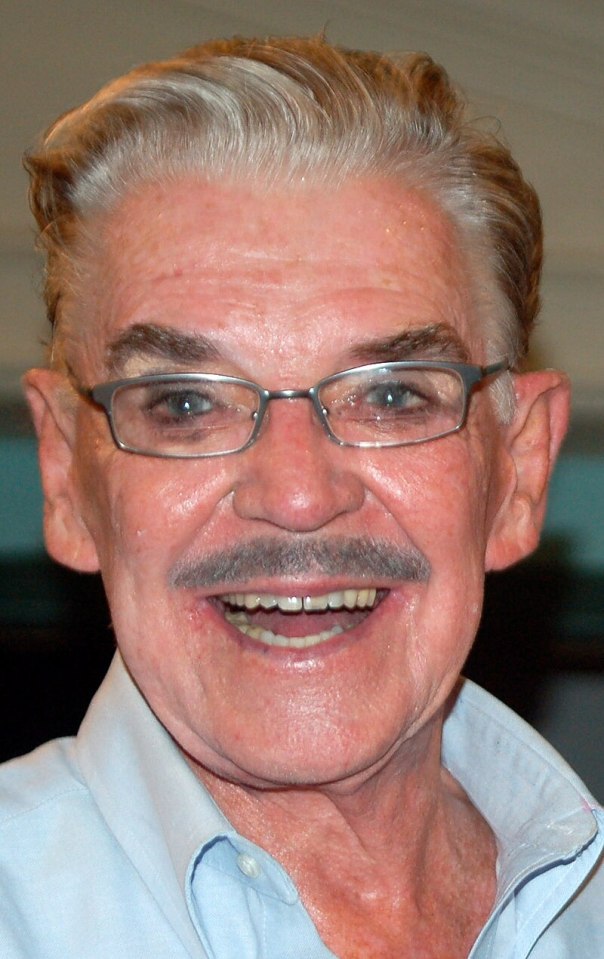 Headshot of a smiling man wearing glasses.