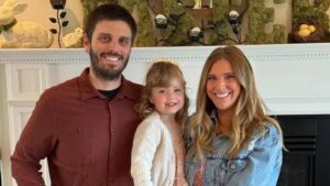 Family portrait in front of a fireplace.