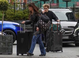 Aimee Osbourne and Wes Leavins leaving a hotel with luggage.