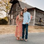 Couple standing in front of a barn.