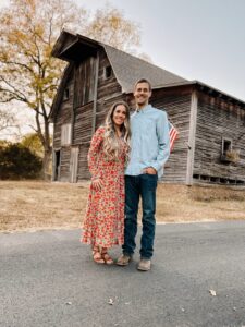 Couple standing in front of a barn.