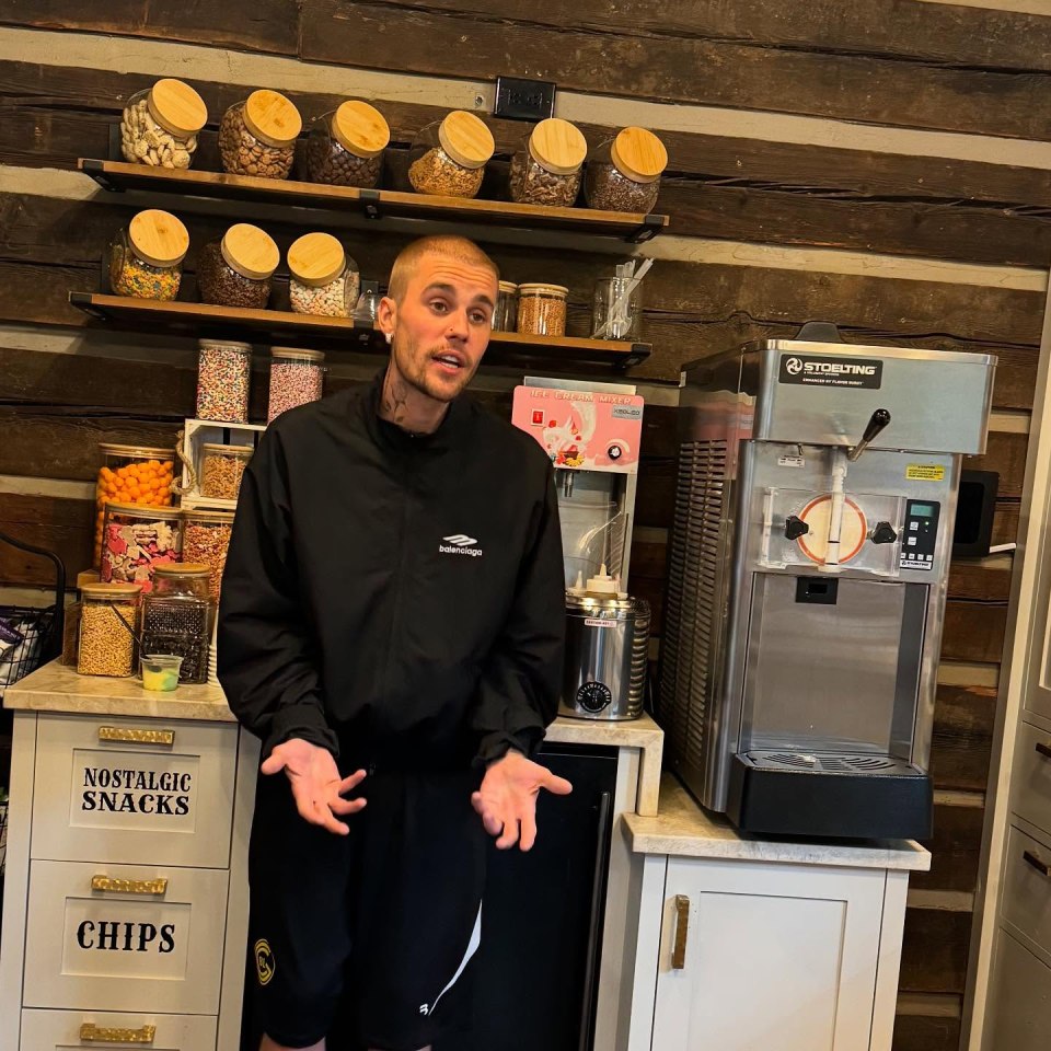 Justin Bieber standing in front of a snack and ice cream station.