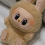 A Labubu figure sitting on a pillow.