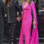 Liz Hurley and Billy Ray Cyrus holding hands at an event.