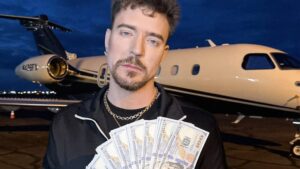 MrBeast holds a spread of cash against a private jet in the background.
