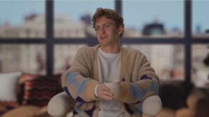 Charlie Zukkor in interview, holding a mug.