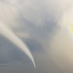 A rainbow next to a tornado