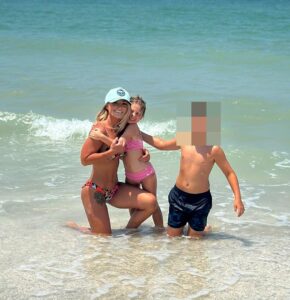 Woman and two children at the beach.