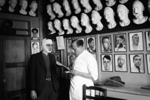 An injured man with a bandage around his face speaks to a doctor
