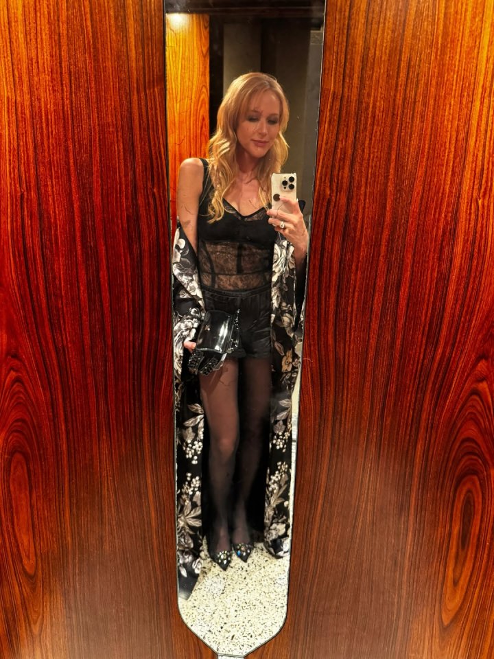 Mirror reflection of a woman in black lace lingerie and a floral kimono.