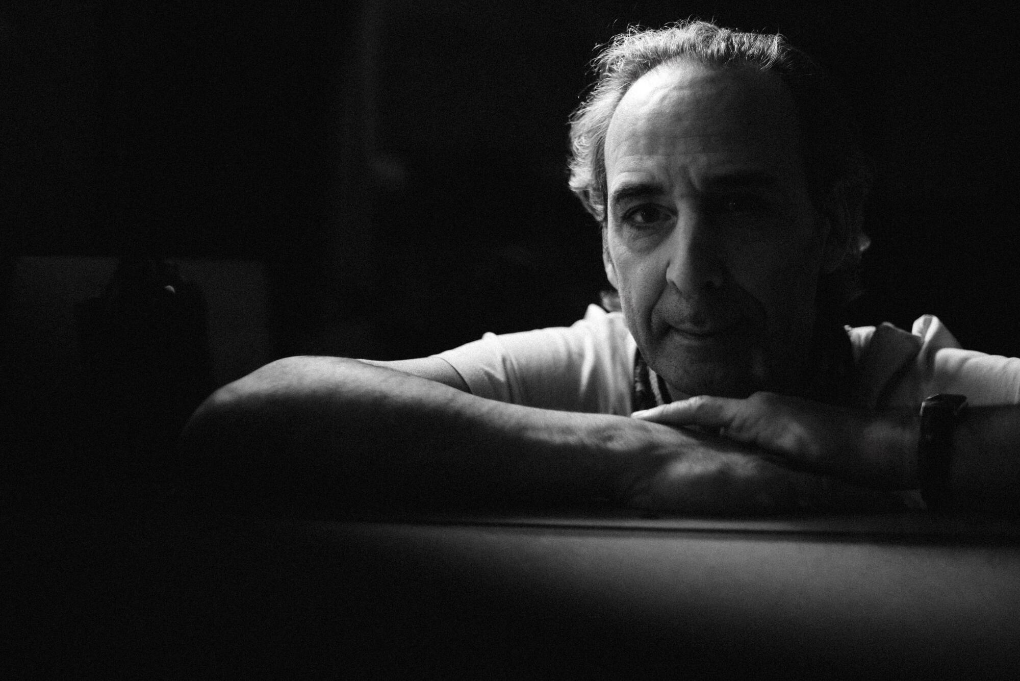 A conductor poses in shadows for the camera.