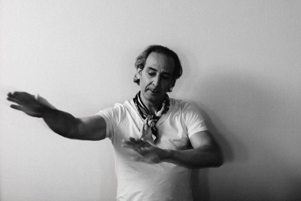 A conductor makes a shape with his hands.