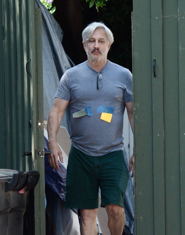 Bronson Pinchot leaving a building.