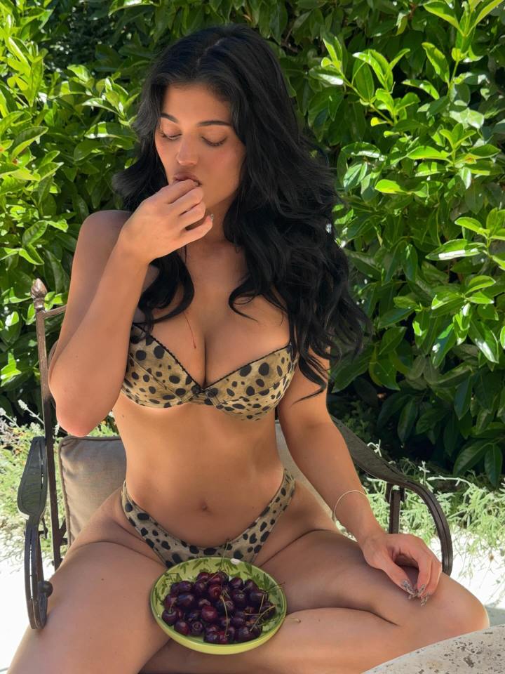 Kylie Jenner eating cherries while wearing a leopard print bikini.