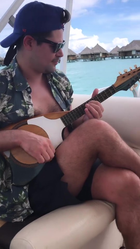 Man playing a ukulele on a boat.