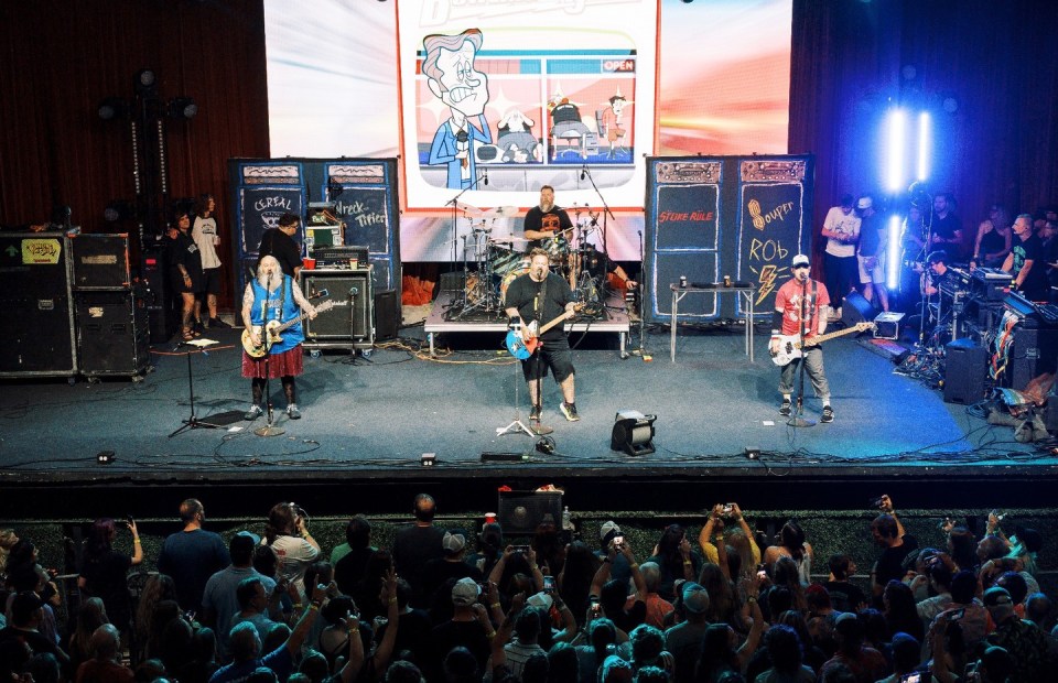 Band performing on stage in front of a crowd.