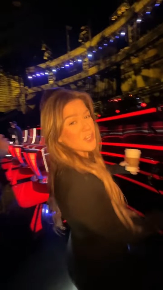 Kelly Clarkson holding a coffee cup backstage before a canceled show.