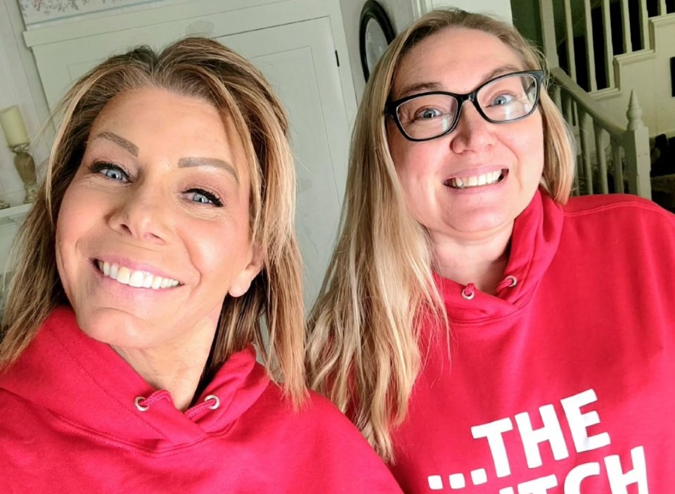 Two women in red hoodies with slogans.