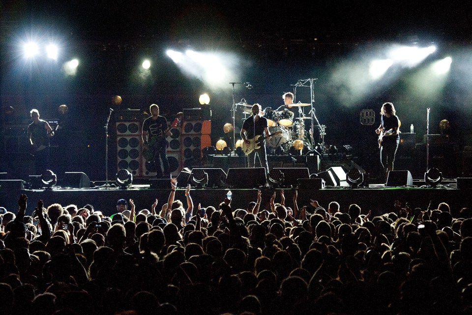 Pearl Jam performing live on stage in front of a large crowd.