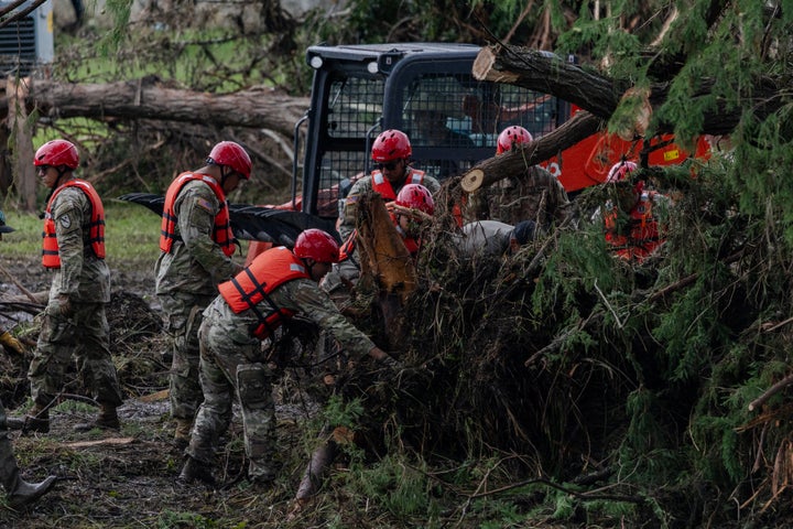 Search and recovery workers dig through debris looking for survivors around Camp Mystic.