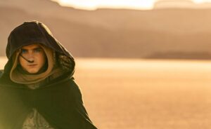 Paul Atreides, eyes spice blue, stands alone in the desert
