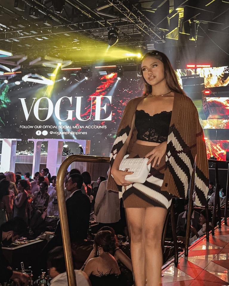 Woman in Burberry outfit at Vogue Philippines event.