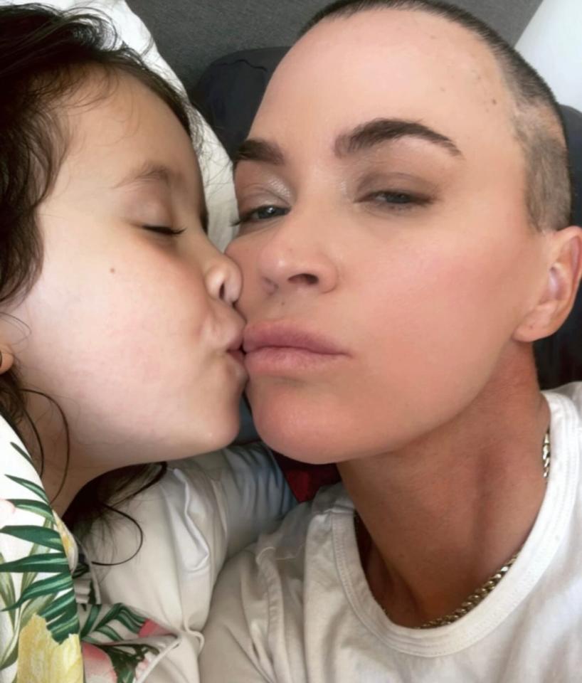A young girl kissing a woman on the cheek.