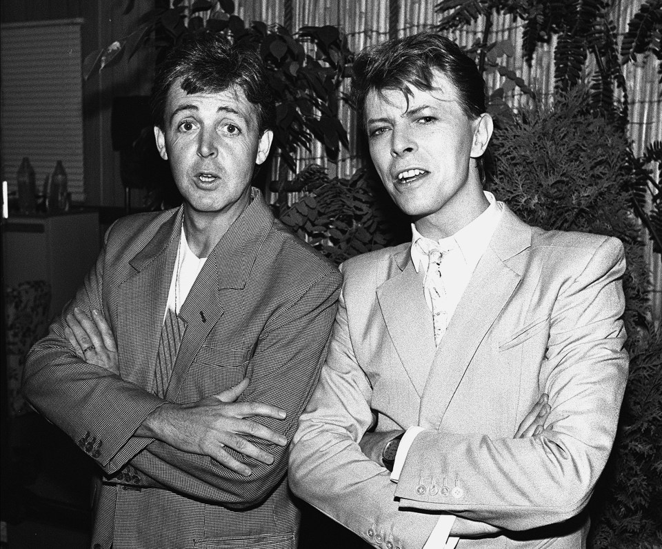 Black and white photo of Paul McCartney and David Bowie backstage at Live Aid.