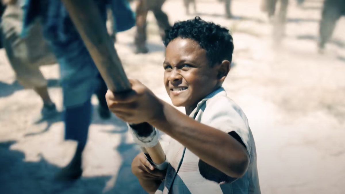 A child holds up a flag pole during a war in Superman