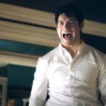 Clark Kent in a white dress shirt yelling in Superman