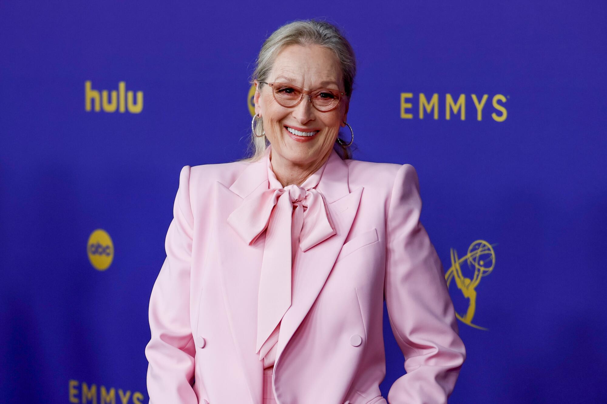 Meryl Streep wears a pink suit and smiles on the red carpet at the Emmys