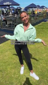 Woman in mint green jacket and black leggings making a TikTok video on a golf course.