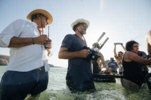 Men shoot a scene standing in water.