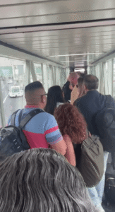 Passengers walking down an airport jet bridge.