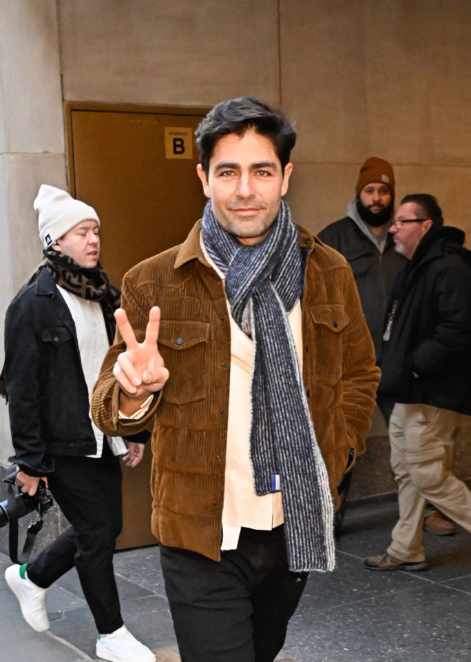 Adrian Grenier giving the peace sign.