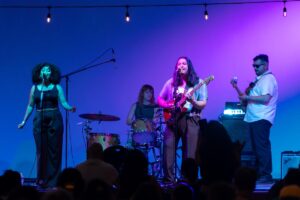 A band onstage with a purple backdrop
