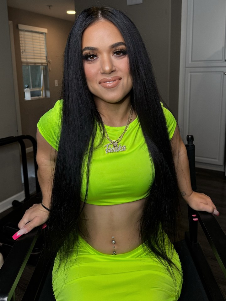 Portrait of a woman with long black hair wearing a lime green crop top and skirt.