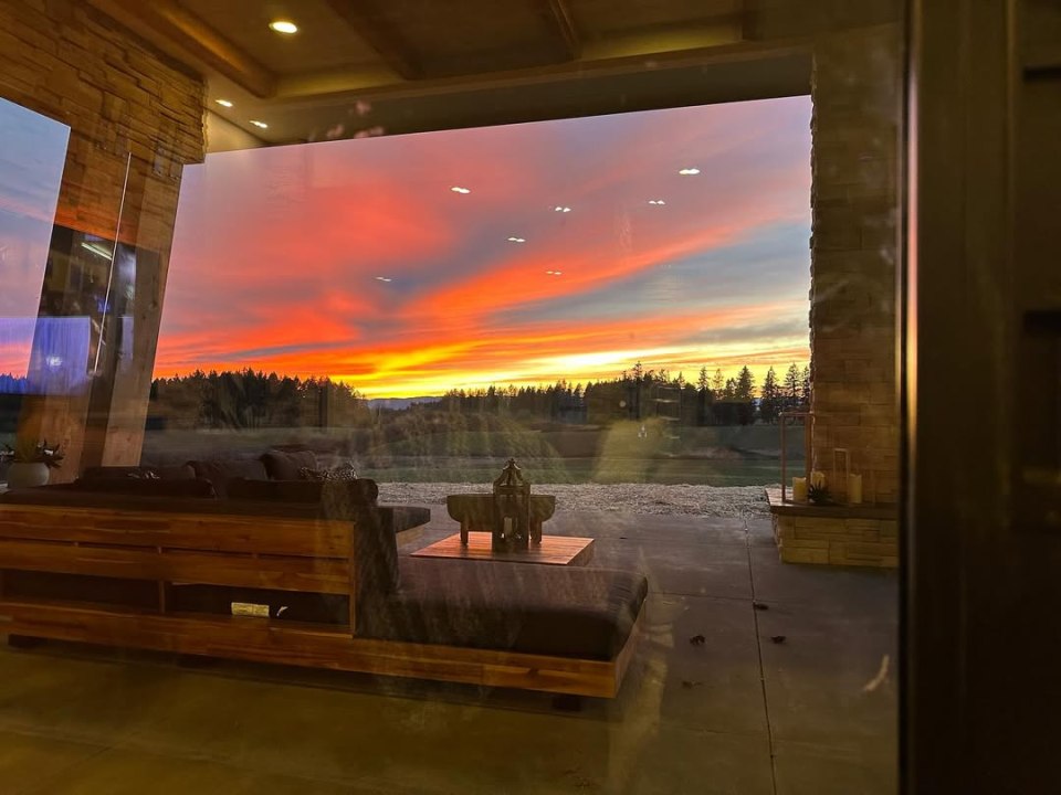 Sunset viewed through a large window from inside a modern home.