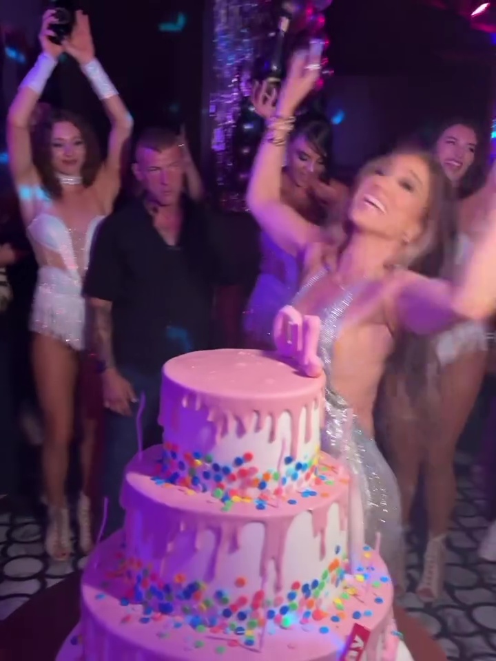 Jennifer Lopez celebrating her birthday with a three-tiered cake.