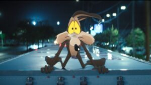 Wile E. Coyote holding on to the top of a truck in Coyote vs. Acme