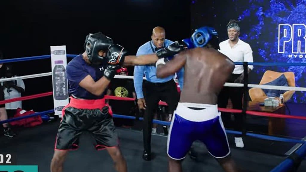 A KSI fan trades blows with a professional boxer in the ring.