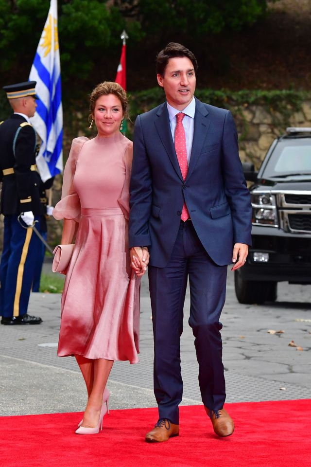 Justin Trudeau and his wife walking on a red carpet.